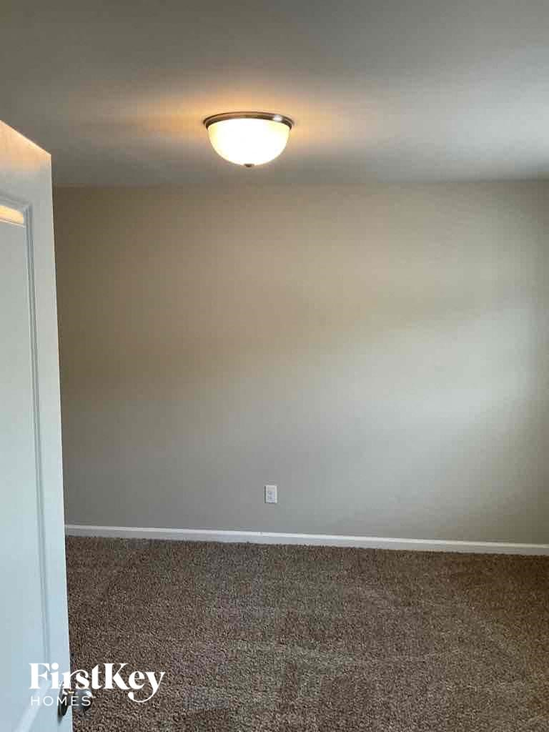 an empty living room with a light fixture on the ceiling