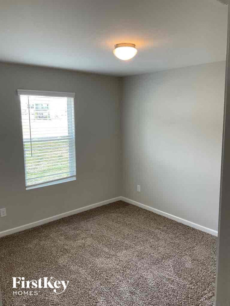 an empty room with gray walls and a window