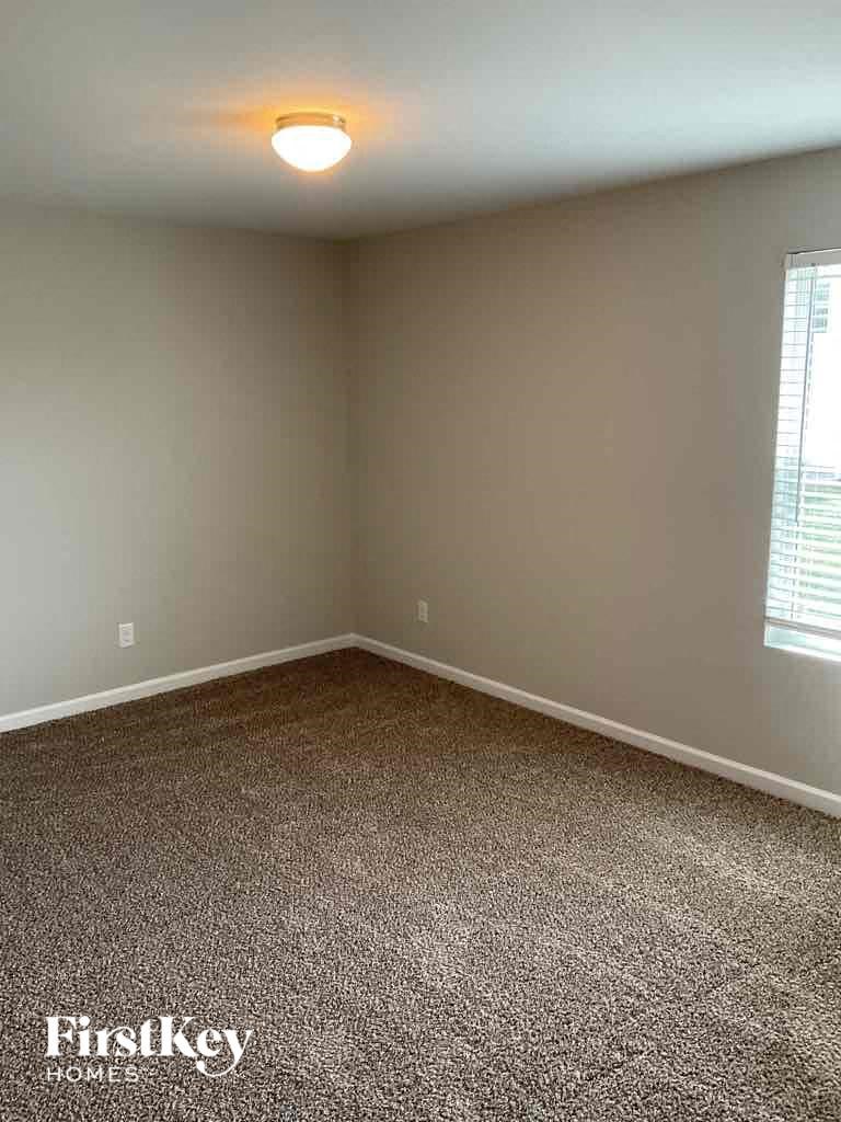 an empty room with carpet and a window