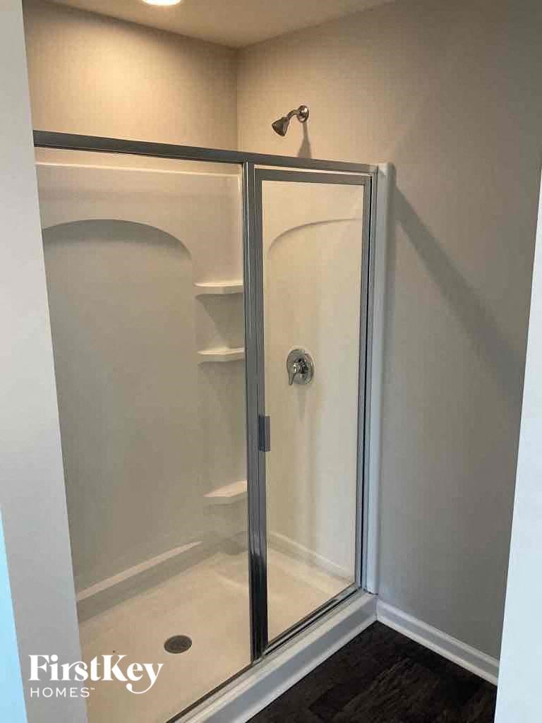 a walk in shower in a bathroom with a glass door