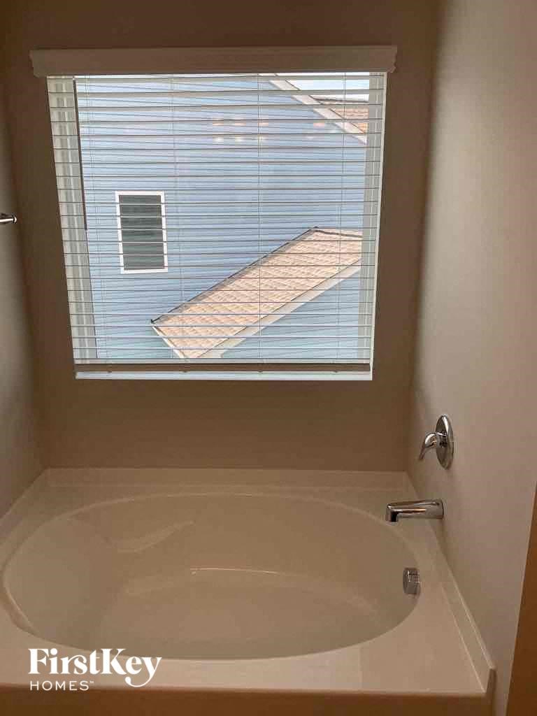 a small bathroom with a tub and a window