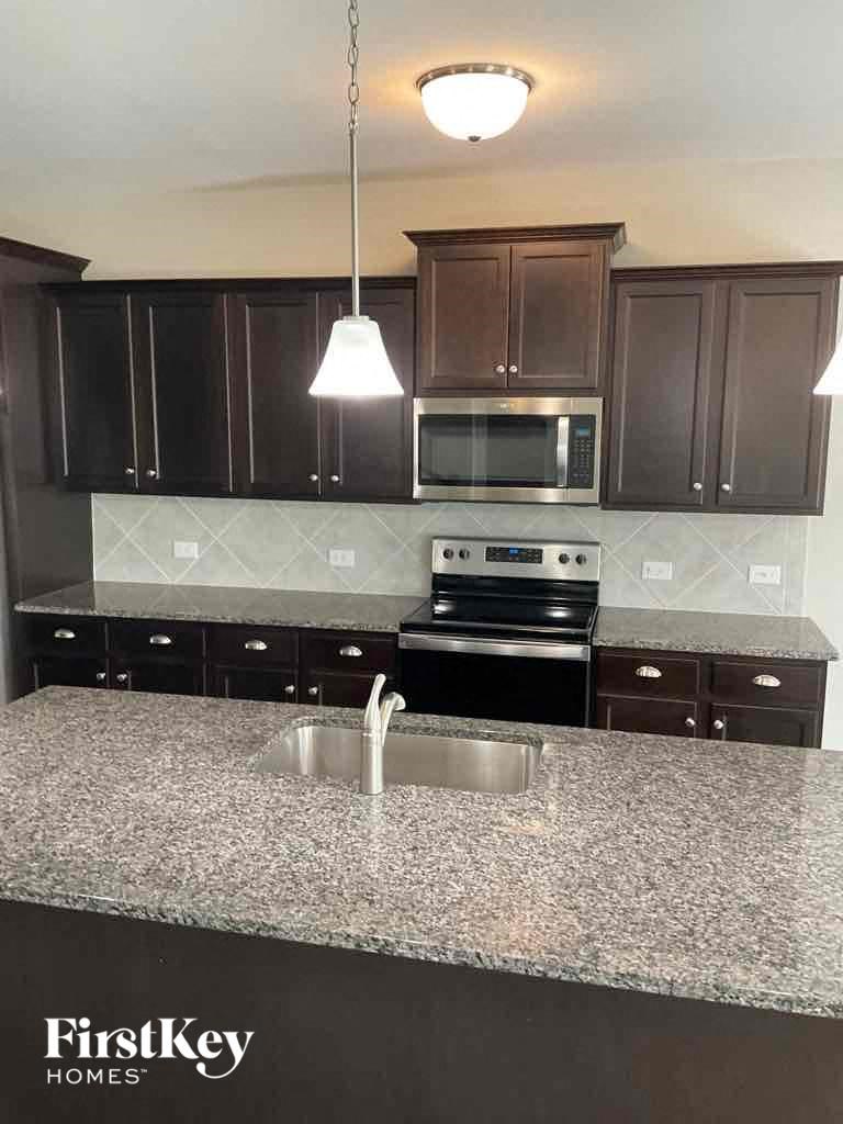 a kitchen with granite counter tops and dark cabinets