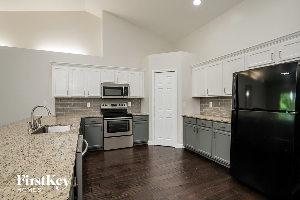 A kitchen with a black fridge and a black oven.