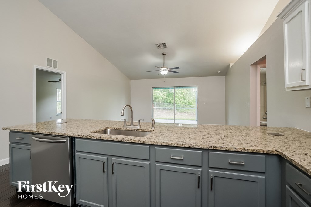 A kitchen with a granite countertop and a window.