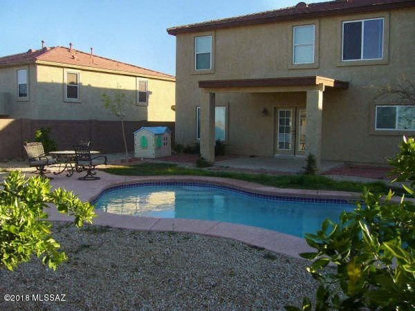 a backyard swimming pool in front of a house
