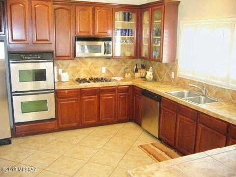 a kitchen with wooden cabinets and stainless steel appliances