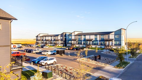 an aerial view of an apartment complex with cars parked outside