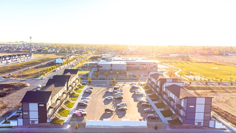 an aerial view of a parking lot with cars and buildings