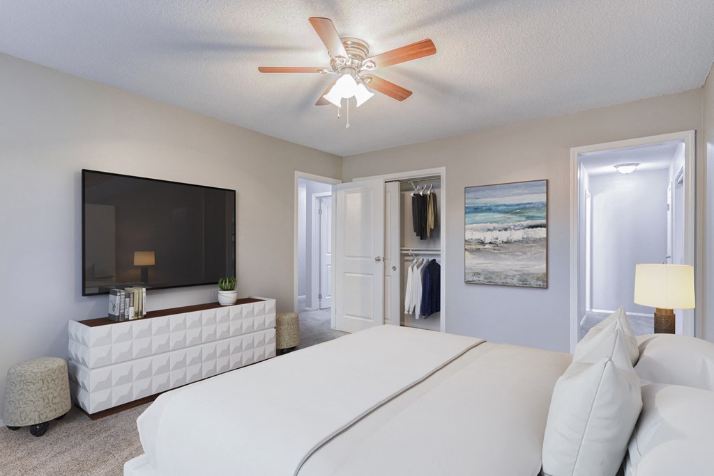a bedroom with a large bed and a ceiling fan