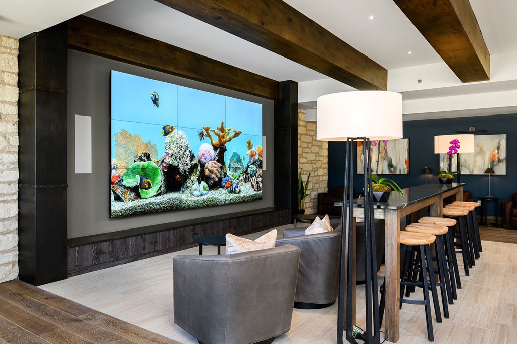 a living room with a large tv and a table with chairs