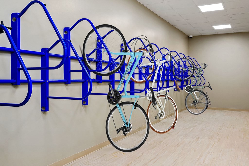 a row of bikes hanging on a blue rack in a room