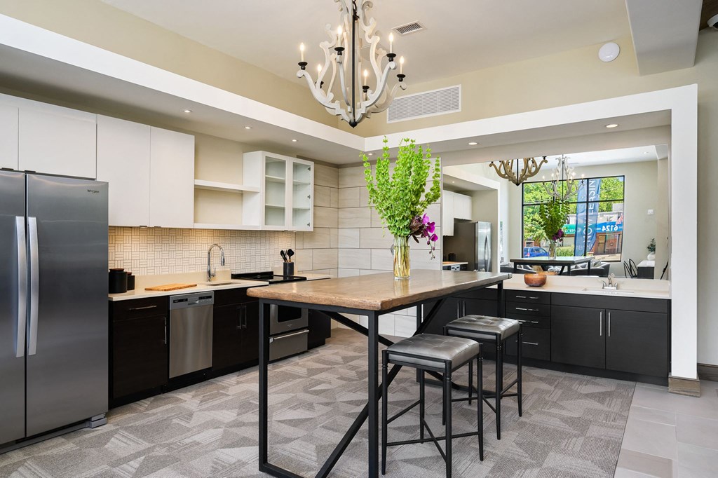 a large kitchen with black cabinets and a table with two stools