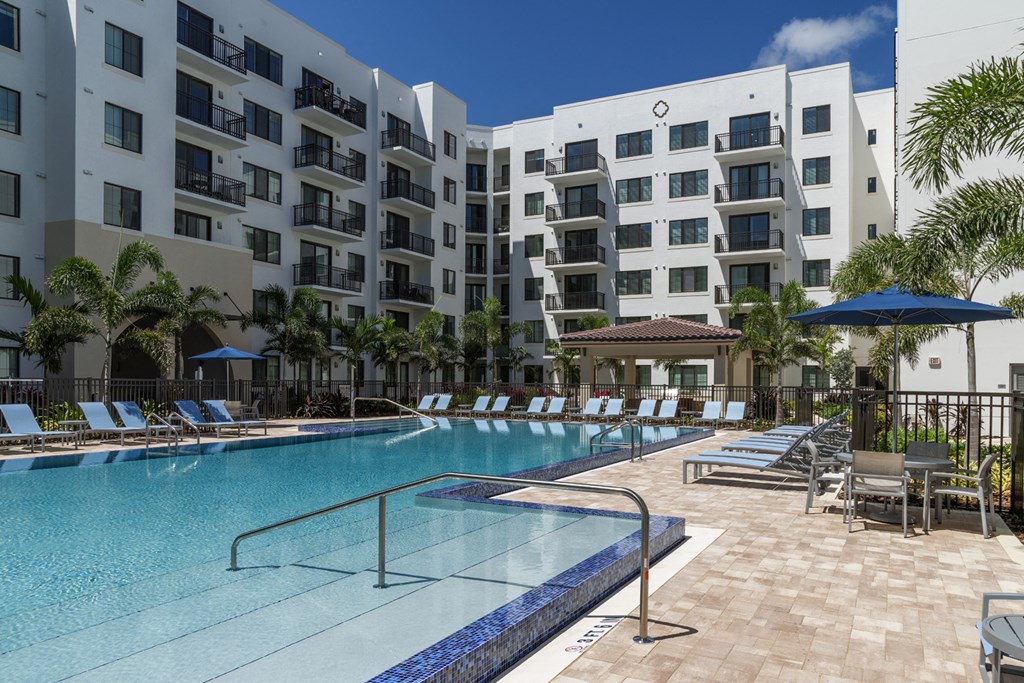 a large swimming pool in front of an apartment building