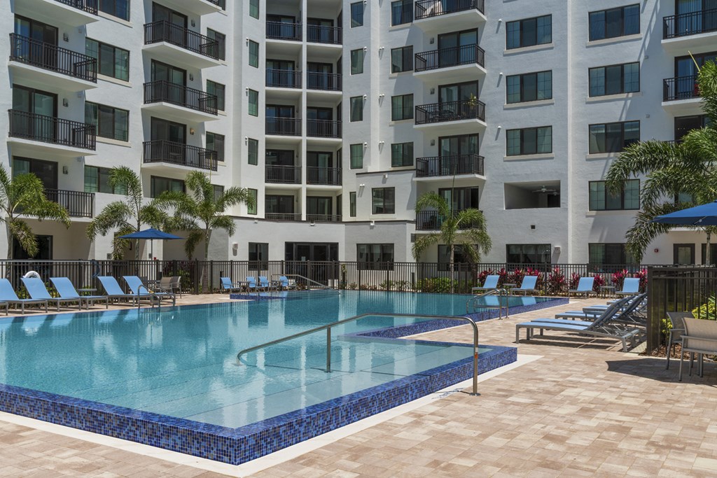 a large swimming pool in front of an apartment building