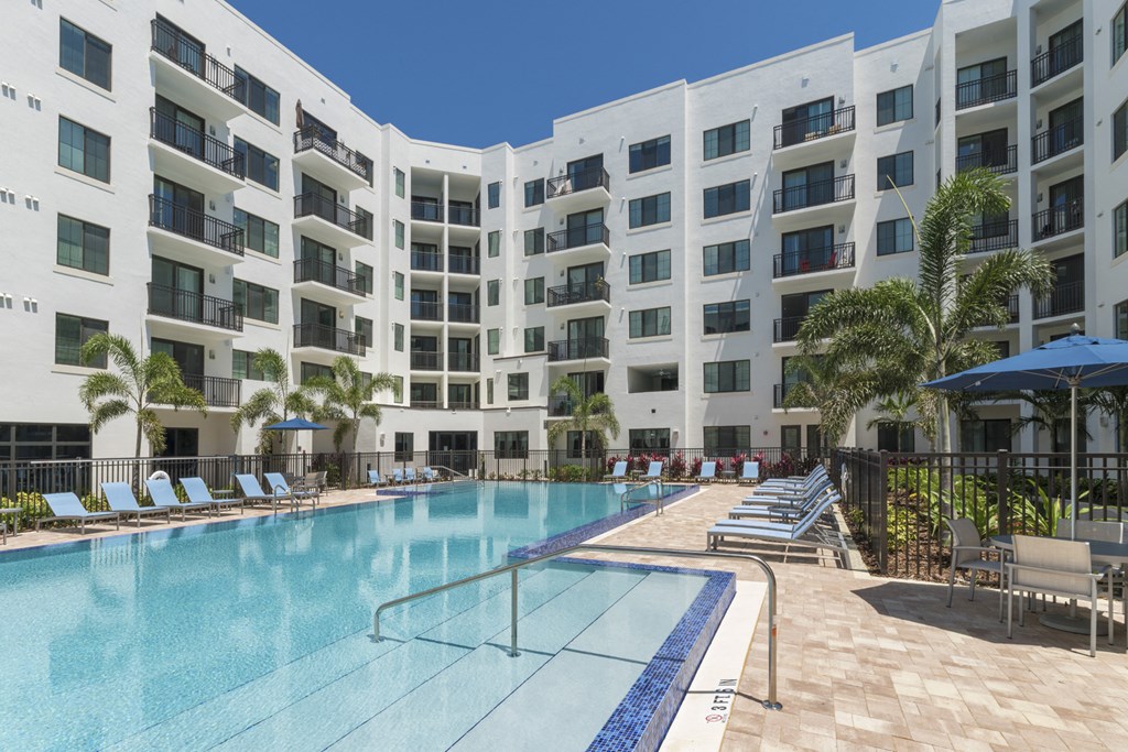 a large swimming pool in front of an apartment building