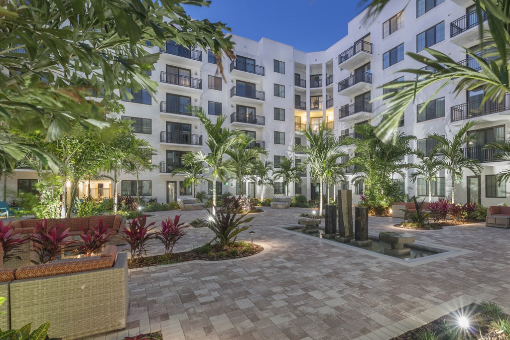 an apartment building with a courtyard and palm trees