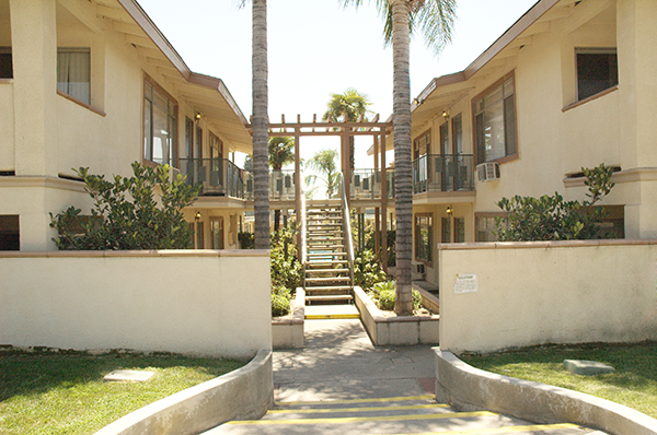 a building with stairs and palm trees in front of it