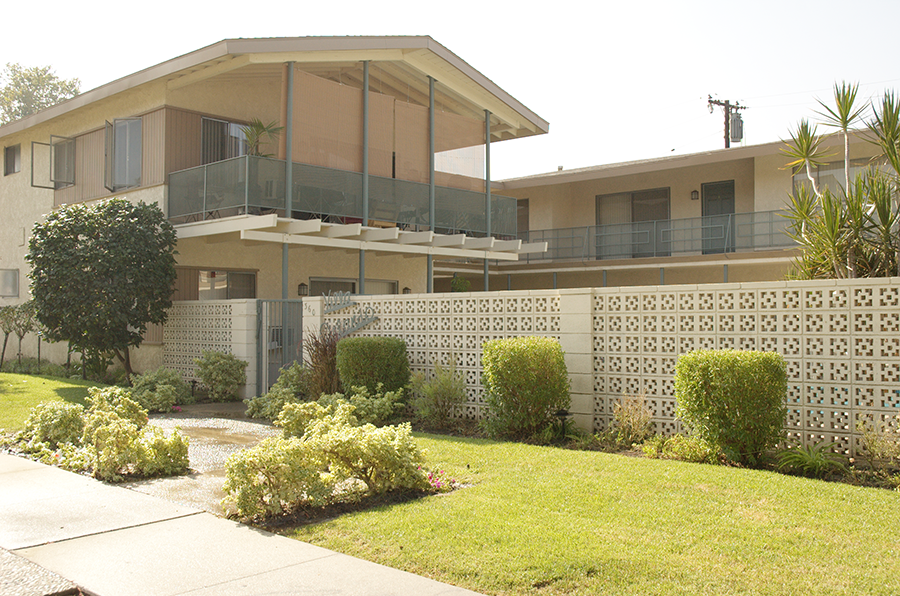 a house with a fence and a lawn in front of it