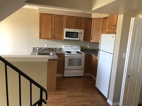 a kitchen with wooden cabinets and a white stove and refrigerator