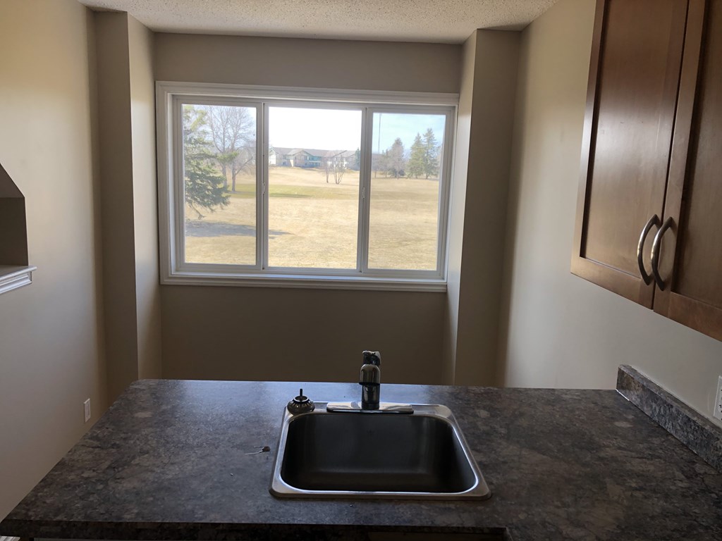 an empty kitchen with a sink and a window