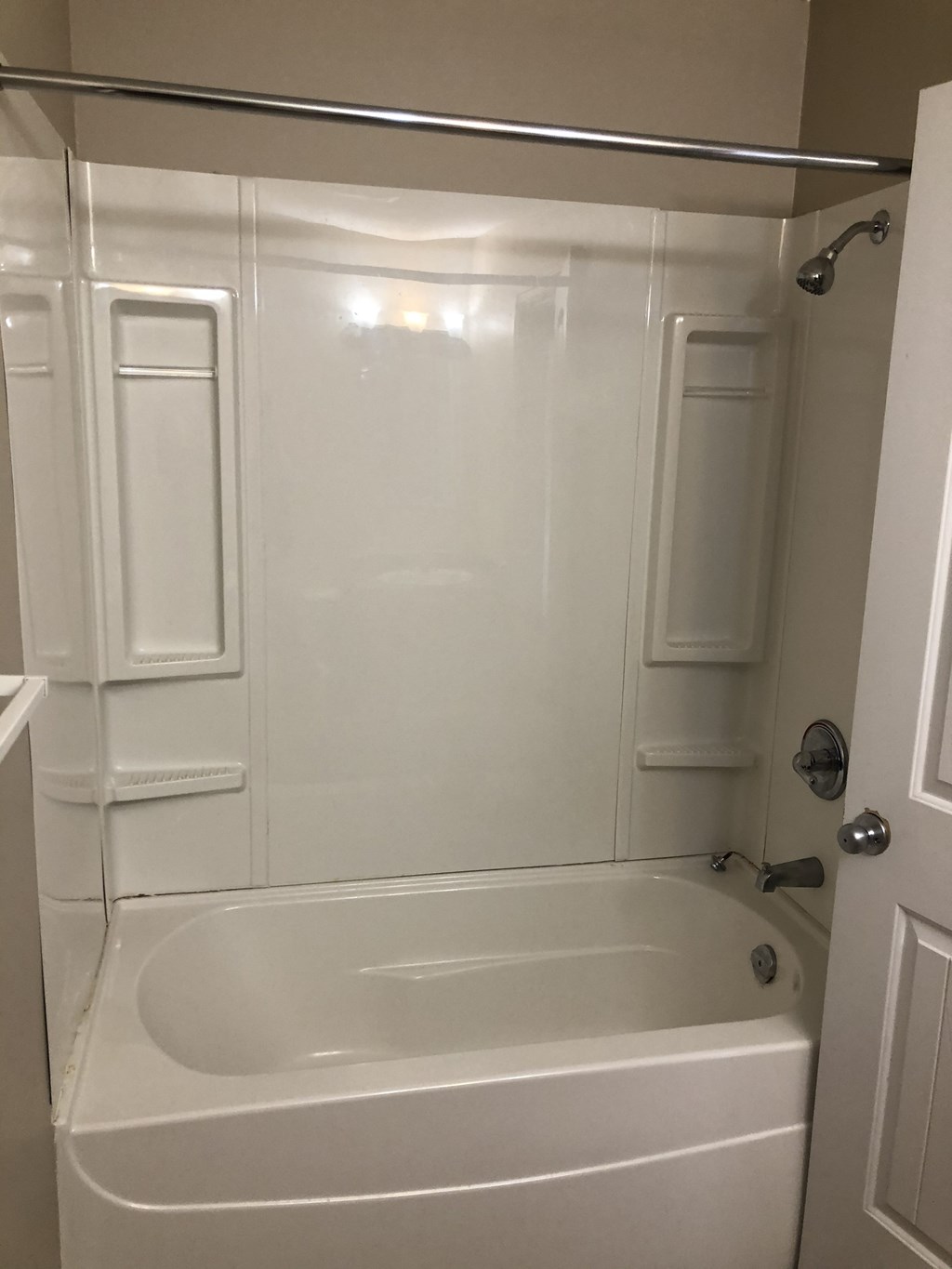 a white bathroom with a tub and a shower