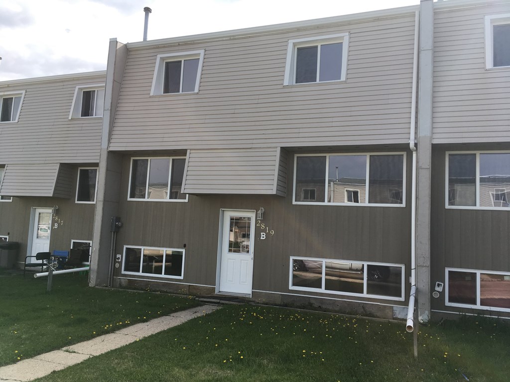 the front of an apartment building with a white door