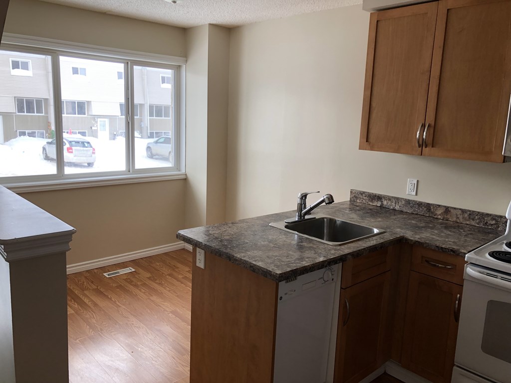 an empty kitchen with a sink and a window