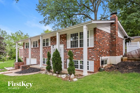 A brick house with a white door and windows.