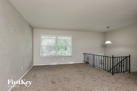 A spacious room with a window and a bicycle rack.