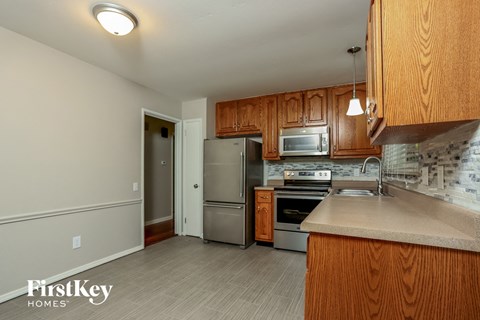 A kitchen with wooden cabinets and a stainless steel refrigerator.