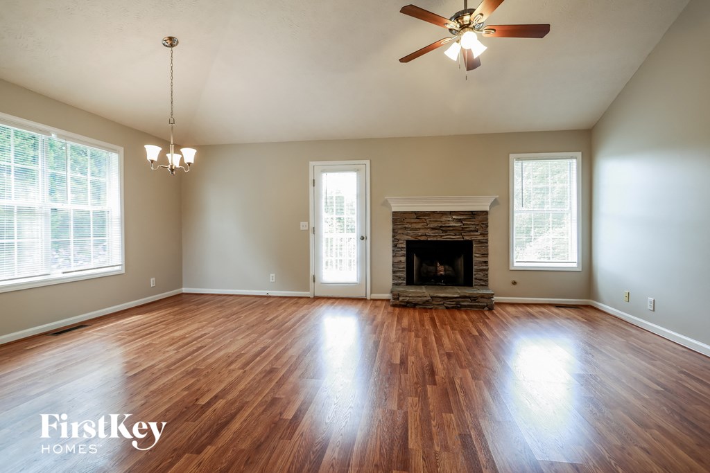 the living room with wood floors and a fireplace