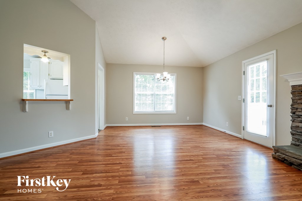 an empty living room with wood floors and a fireplace