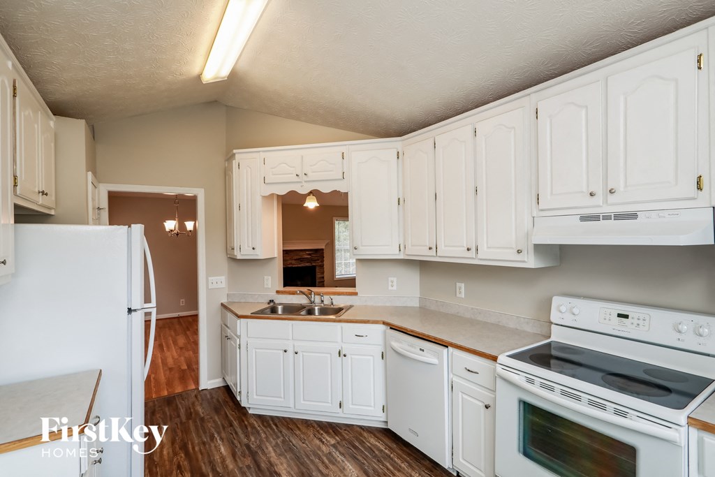 an image of a kitchen with white cabinets and appliances