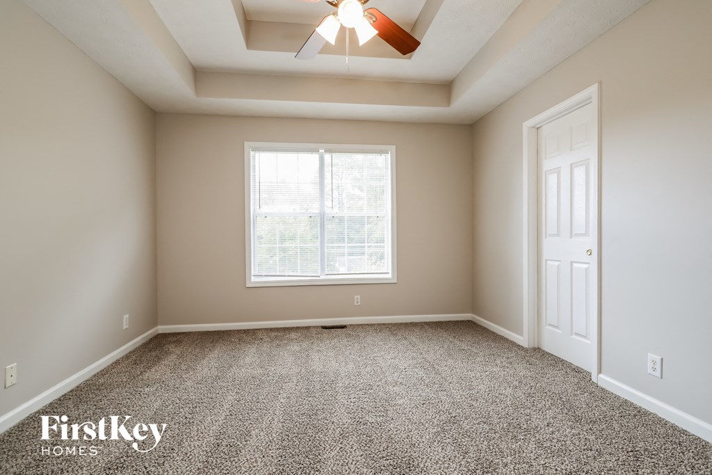 an empty room with a ceiling fan and a window