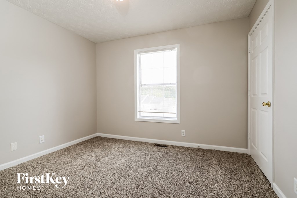 a empty room with carpet and a window