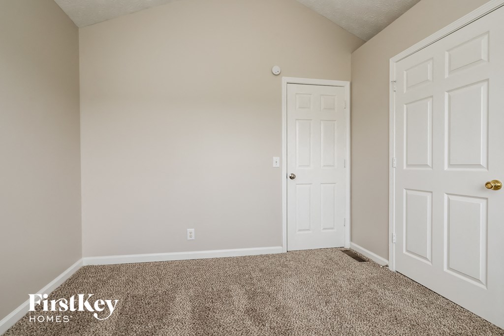 a bedroom with a carpeted floor and white doors