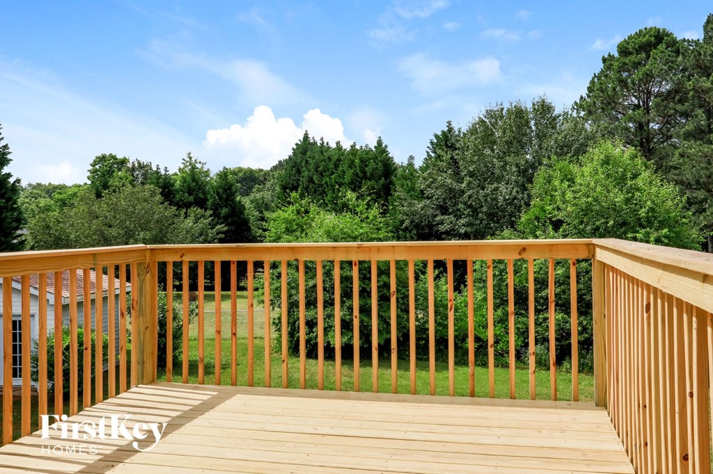 a deck with a view of a yard and trees