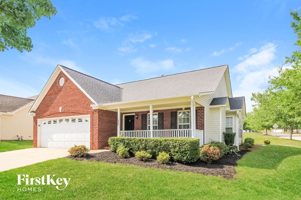 a brick house with a porch and a white garage door