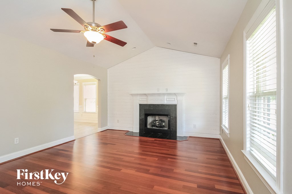 a living room with a fireplace and a ceiling fan
