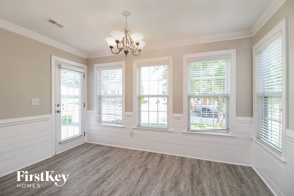a dining room with a chandelier and three windows