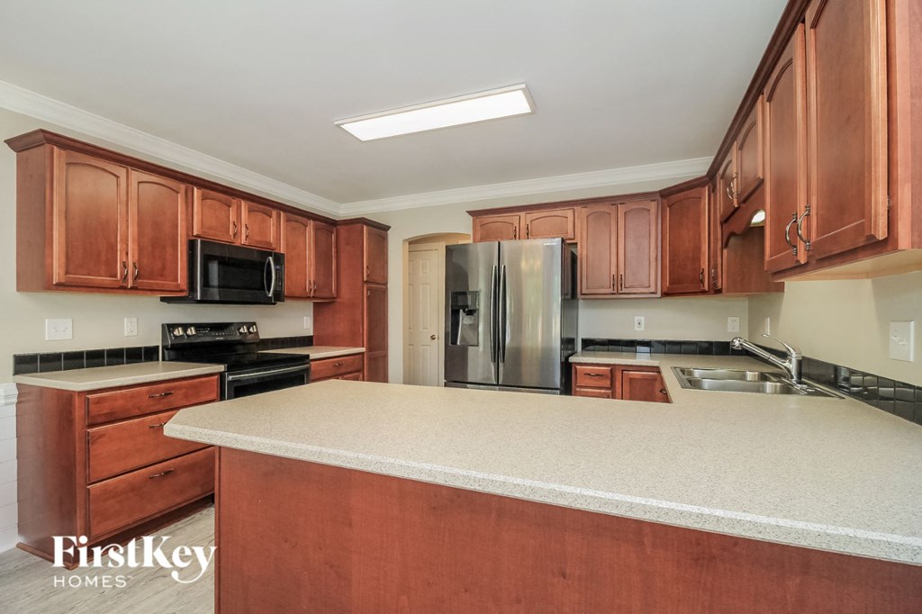 a kitchen with wooden cabinets and a white counter top