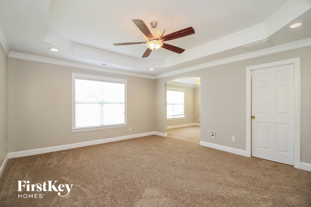 a living room with a ceiling fan and a white door