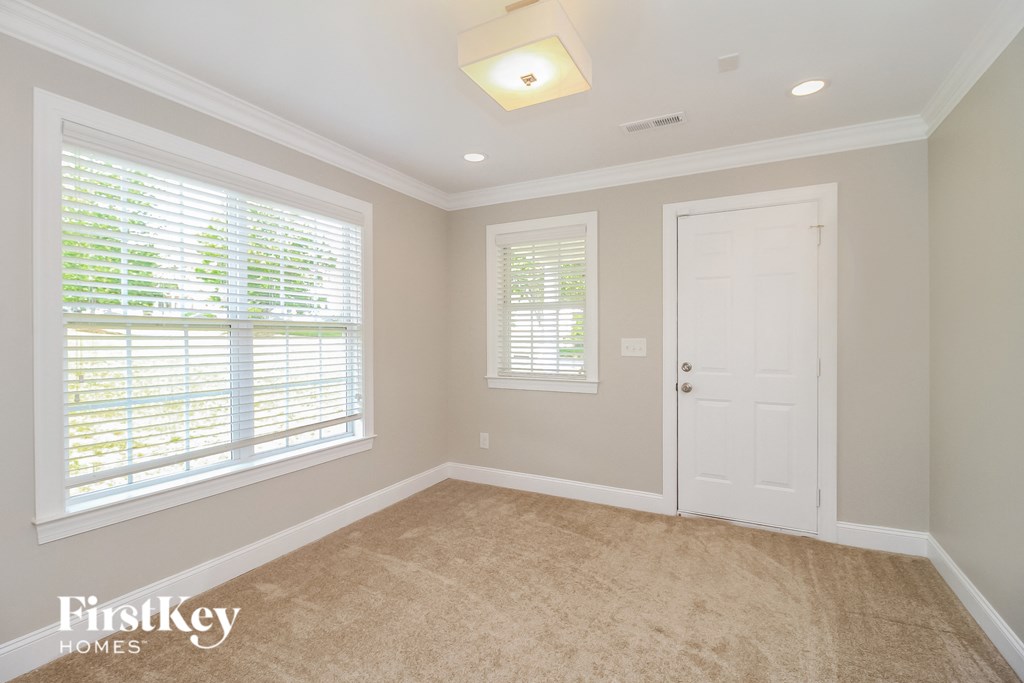 an empty room with a white door and window