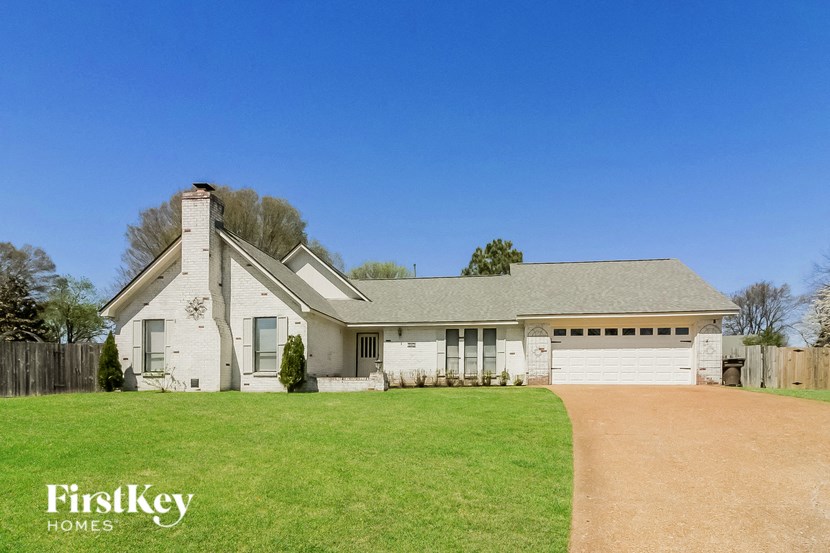 a white house with a white garage and a green lawn