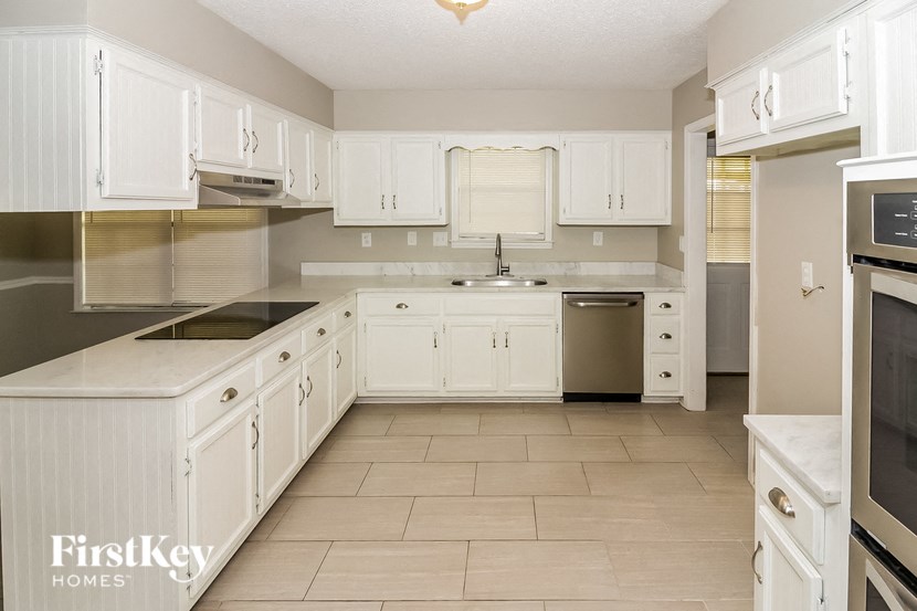 a white kitchen with white cabinets and stainless steel appliances