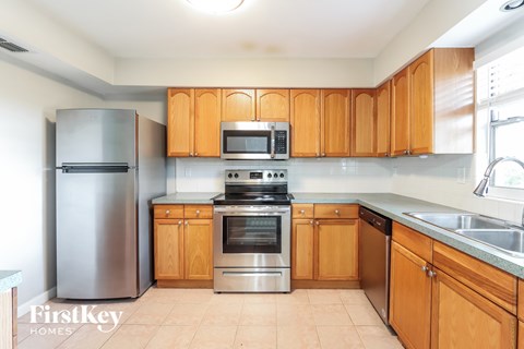 A kitchen with wooden cabinets and stainless steel appliances.