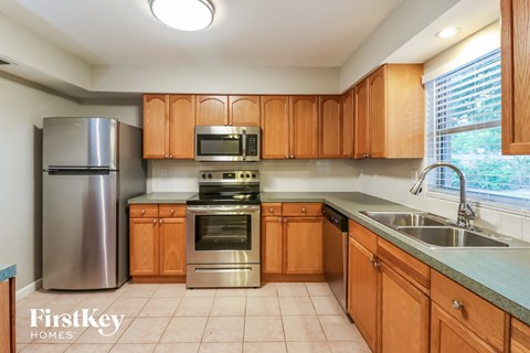 A kitchen with wooden cabinets and a stainless steel refrigerator.