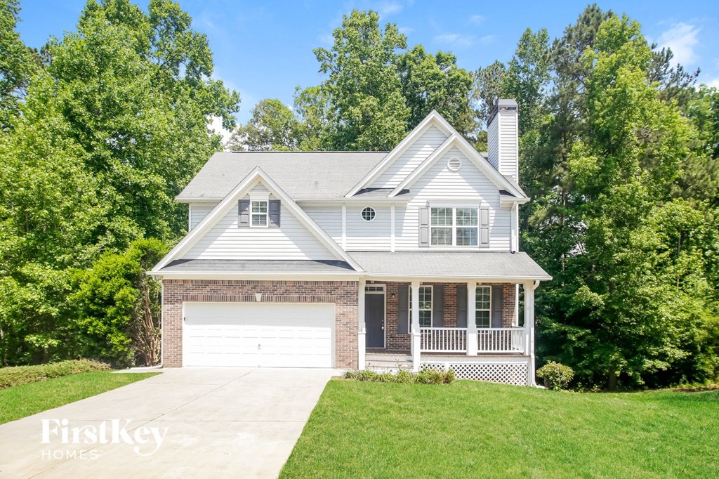 A house with a garage is surrounded by greenery.