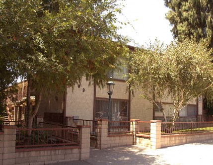 a building with a fence and trees in front of it