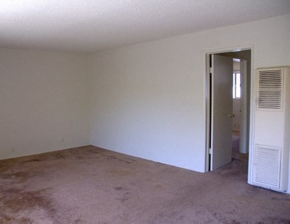 an empty living room with an air conditioner in it